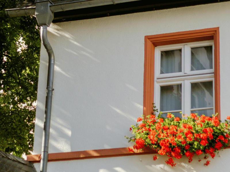 Façade avec encadrements de fenêtres peints et fleurie